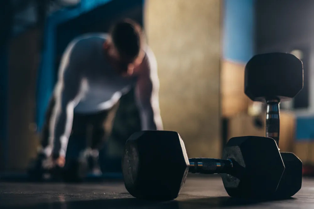 hombre y pesos que deben adaptarse adecuadamente al tipo de entrenamiento
