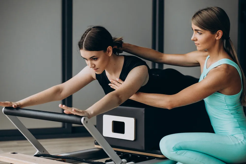 una mujer realiza entrenamiento correctivo bajo la supervisión de un especialista