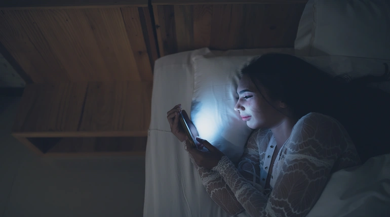 mujer mirando el teléfono inteligente por la noche