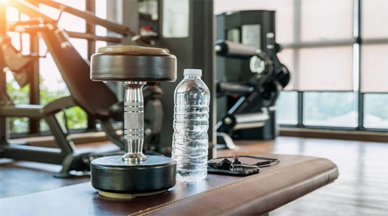 mancuernas y botella de agua en el gimnasio