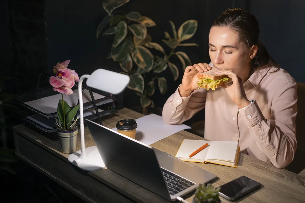 La mujer come bocadillos ricos en calorías por la noche.