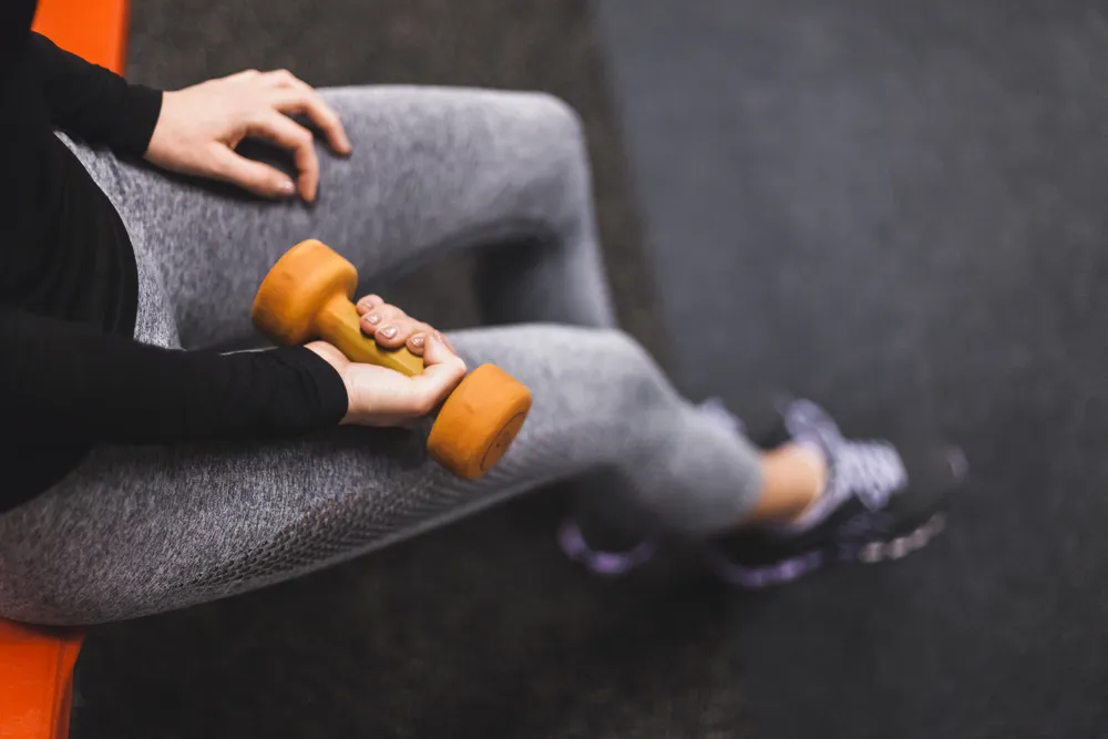 una mujer se pregunta cómo elegir un peso para entrenar
