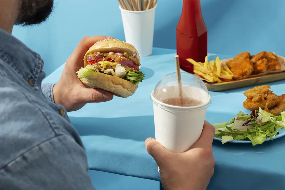 el hombre come comida rápida