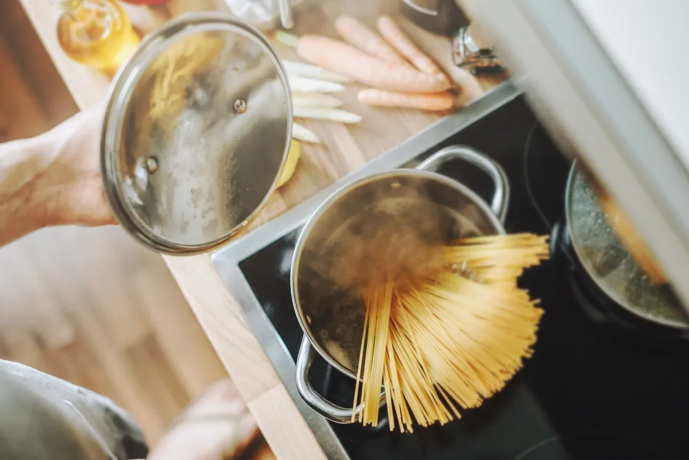 El hombre prepara platos de pasta.