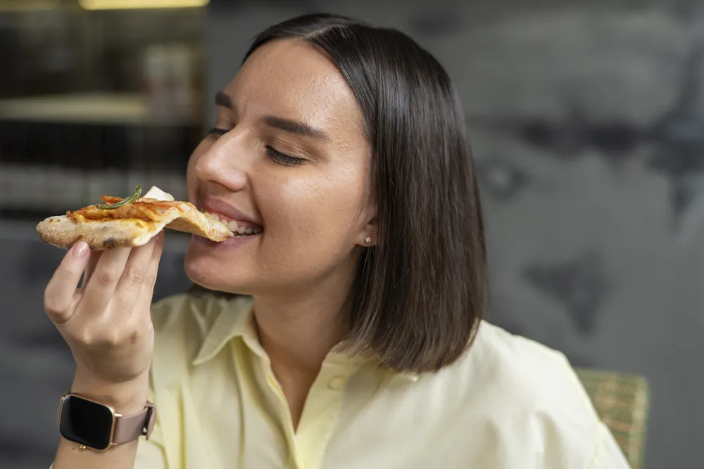 mujer come pizza para una cena saludable