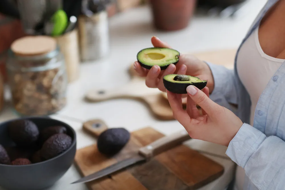 mujer sosteniendo un aguacate